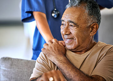Image shows a patient with a reassuring hand on their shoulder from a caring medical professional