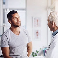 Image shows a patient discussing his issue with a medical professional