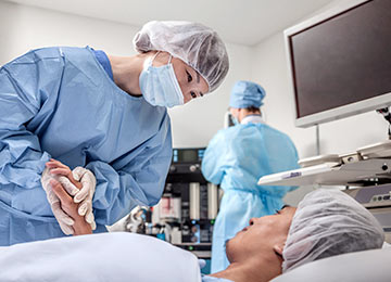 An image showing a caring clinician tending to a patient within an operating theatre