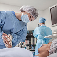 An image showing a caring clinician tending to a patient within an operating theatre