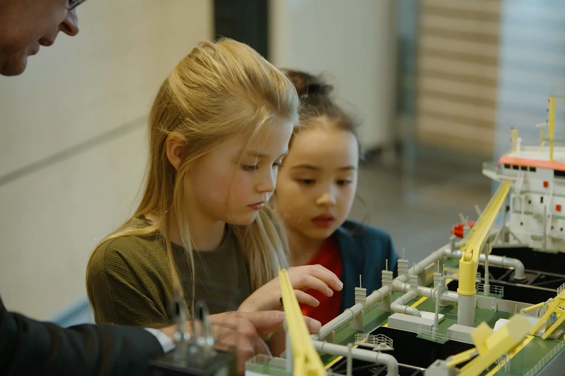 Twee meisjes bekijken een schaalmodel van een baggerschip bij Boskalis