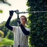 Mand justerer på Husqvarna stanghækkeklipper