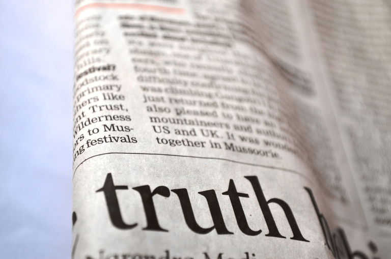 Et nærbilde av en avis med ordet «truth» tydelig fremhevet, som symboliserer betydningen av sannhet, journalistikk og kildekritikk i mediene.