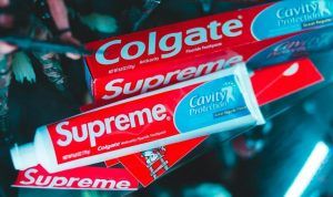 Tannkremtuber fra Colgate og Supreme, fotografert i butikkmiljø. Bildet illustrerer merkevare og produktdesign med fokus på emballasje.