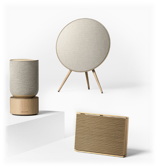 Tre Bang & Olufsen-høyttalere med detaljer i treverk og minimalistisk design, som viser hvordan naturlige materialer kan gi et premium og eksklusivt preg./ Fotomontasje: R. S.