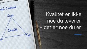 Et notatark med rutenett viser en håndtegnet 'Triple Constraint'-modell i prosjektledelse, der et trekantdiagram illustrerer forholdet mellom 'Scope', 'Cost' og 'Time', med 'Quality' i midten. Ved siden av ligger en gullfarget penn på en mørk treflate. På høyre side av bildet står teksten: 'Kvalitet er ikke noe du leverer – det er noe du er' i hvit skrift.