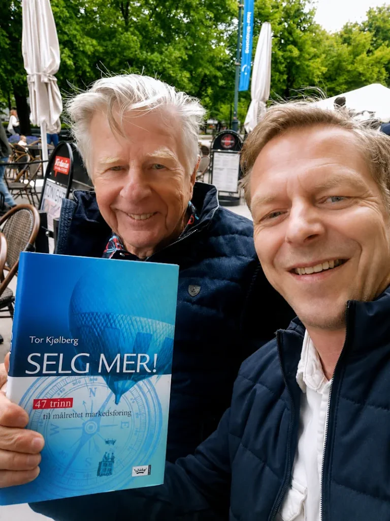Author Tor Kjølberg and a reader holding the book Sell More: 47 Steps to Targeted Marketing at an outdoor café. The image illustrates themes of sales, marketing, business strategy, and how experience can deepen our understanding of familiar concepts.