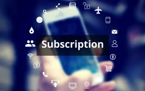 En uskarp bakgrunn med en hånd som holder en mobiltelefon. I forgrunnen står ordet 'Subscription' i hvit skrift på en svart rektangulær boks. Rundt teksten er en sirkel av hvite ikoner som representerer ulike digitale tjenester, som skytjenester, e-handel, e-post, kommunikasjon og nettverk, noe som symboliserer abonnementstjenester i en digital kontekst.
