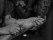 grayscale photo of a person holding a barefoot