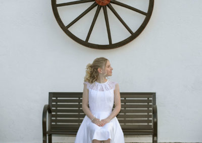 Konfirmationsbilleder med pige på en bænk