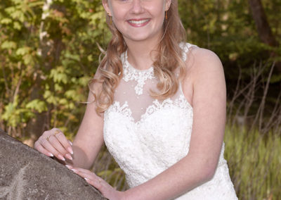 Konfirmationsbilleder med pige som støtter sig på en sten