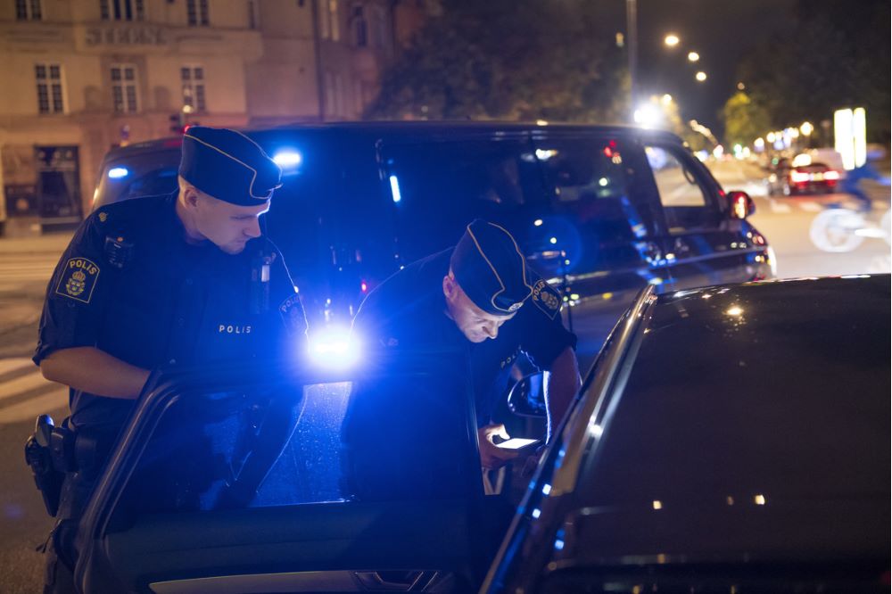 Två poliser utför en fordonskontroll. Foto.
