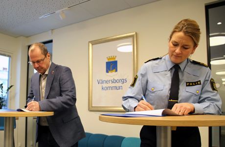 Kommunstyrelsens ordförande Benny Augustsson och Jenny Wester, lokalpolisområdeschef i Östra Fyrbodal, skriver under årets medborgarlöfte.