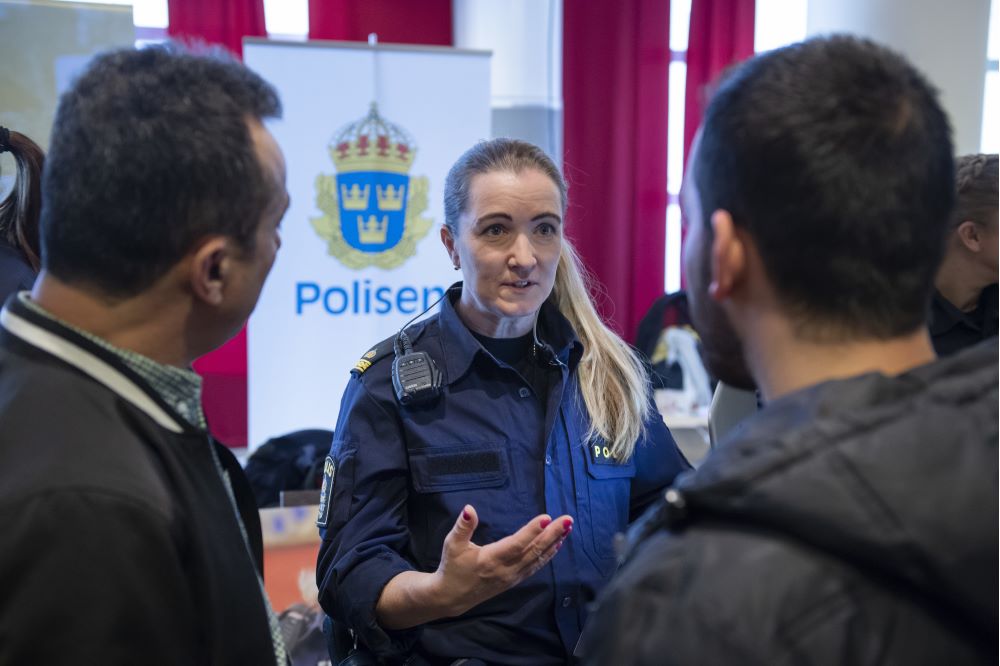 Polis talar med två personer.