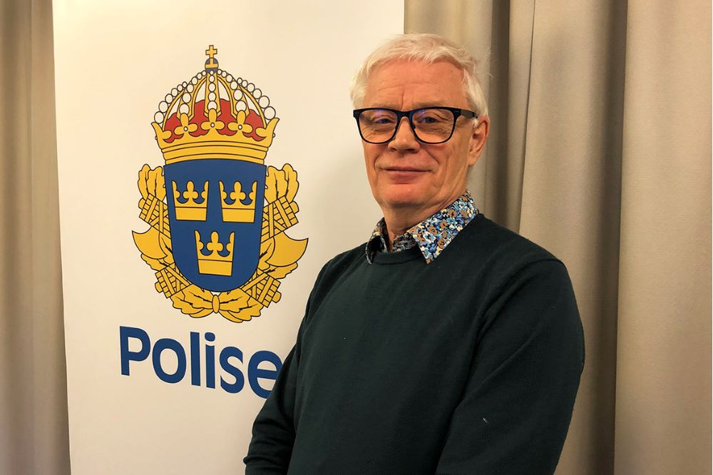 Ulf polis i Stockholms city framför polisens logotype.