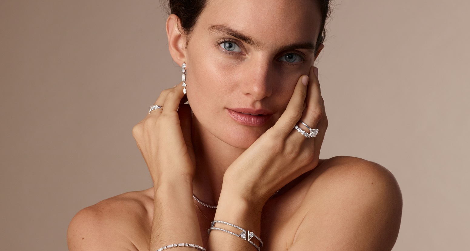 Model showcasing tennis bracelets and necklaces, drop earrings and double row bangles