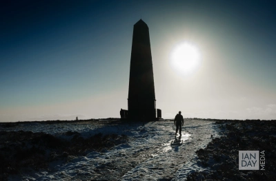 A hiker walks up to Captain Cook's Monument on a cold winter’s day. The monument is situated near to Great Ayton, North Yorkshire.