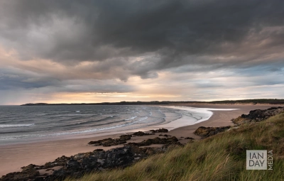 Clouds and waves roll in towards the beach on Ynys Llanddwyn, North Wales.