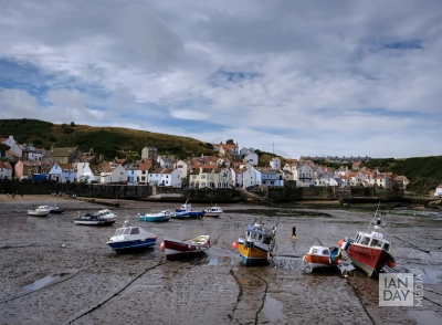 Fishing boats rest on the sand at low tide at the North Yorkshire seaside village of Staithes.