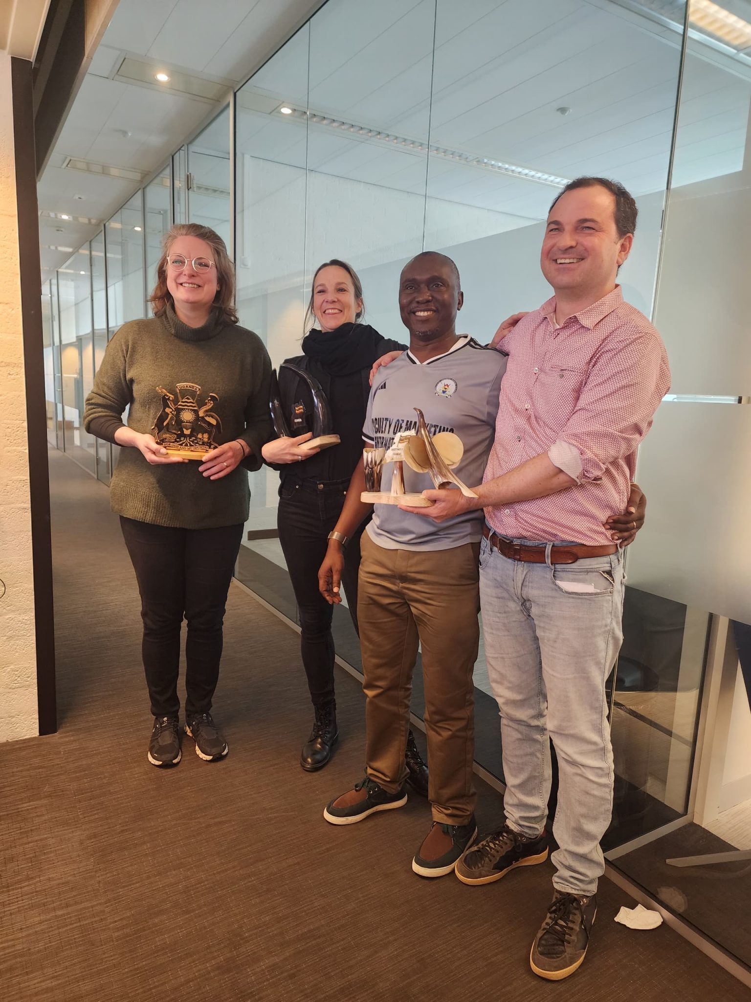 Photo moment as Prof David Katamba recognizes Prof Christopher Wickert, Assoc. Prof. Nadine Arnold, Assoc. Prof Christine Mosser with souvenirs from Uganda