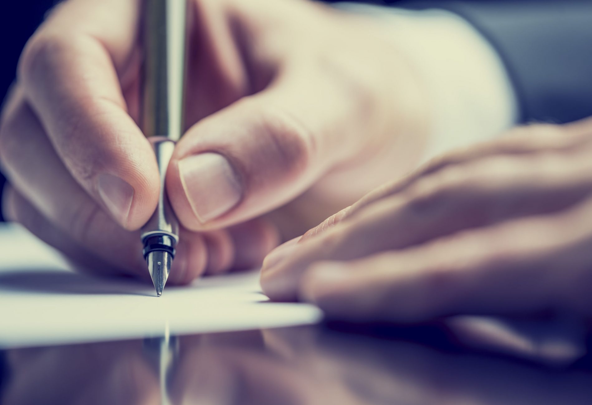 Retro image of a man writing a note Retro effect faded and toned image of a man writing a note with a fountain pen.