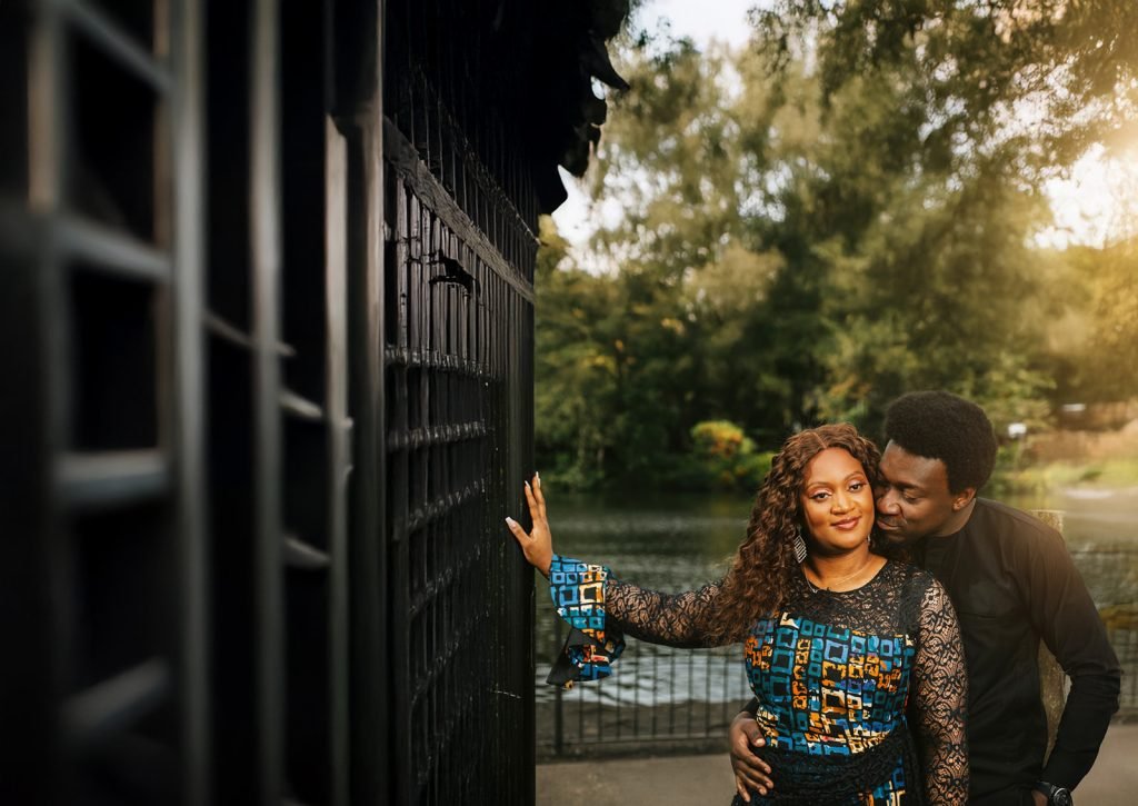 Couple embracing near serene water.