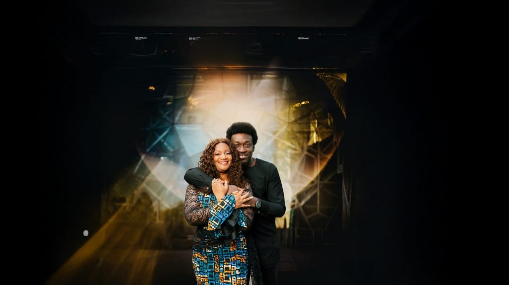 Couple embracing in artistic lighting.