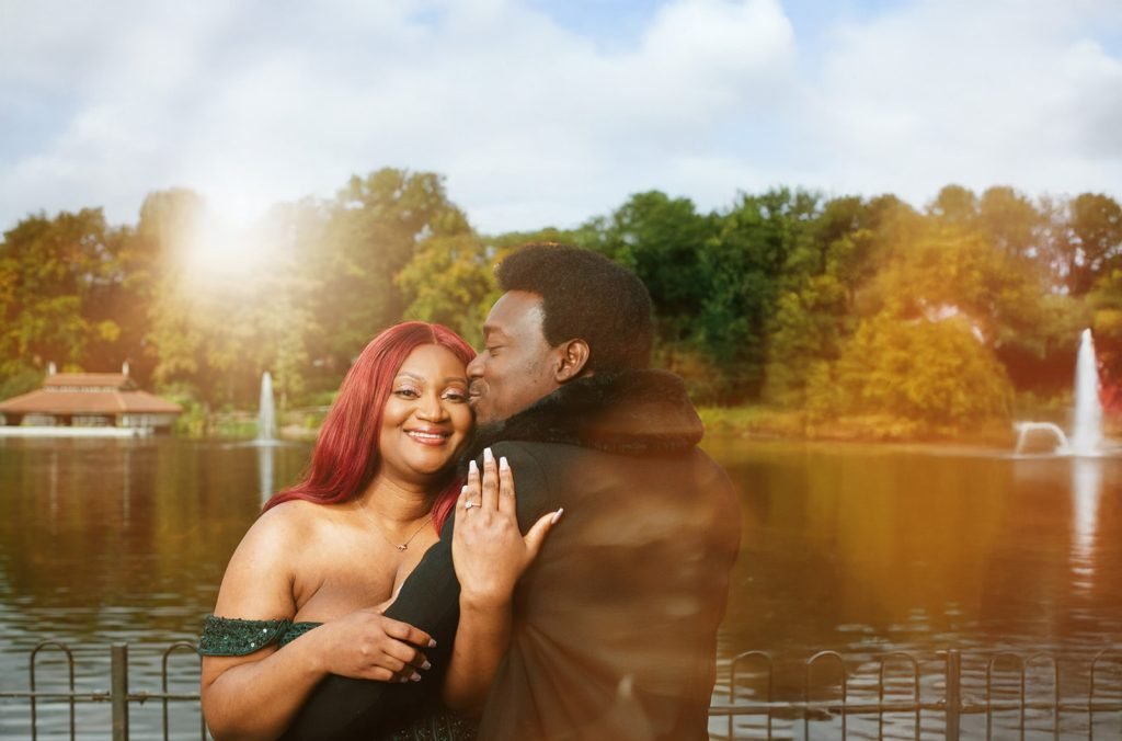 Couple embracing by serene lake.