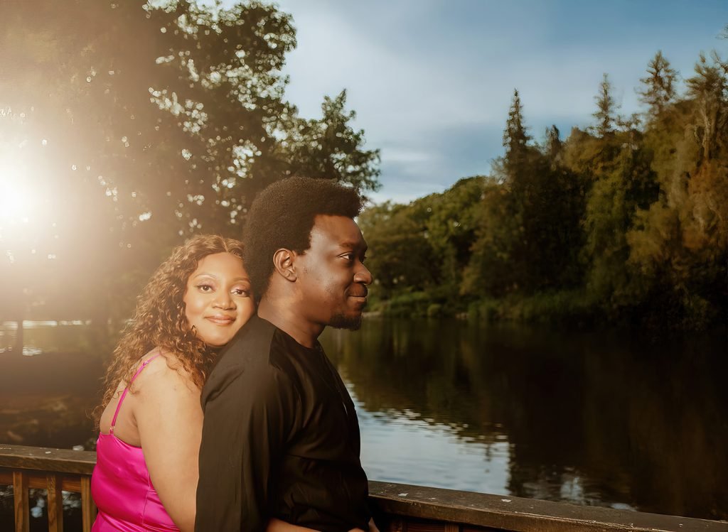 Couple embracing by serene lake.