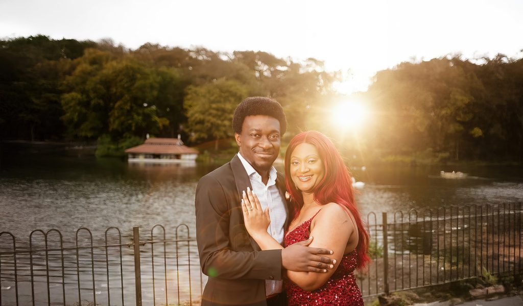 Couple embracing by serene lake.