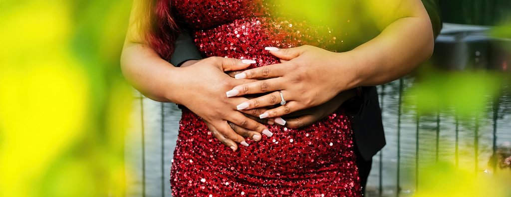 Couple embracing with hands on belly.