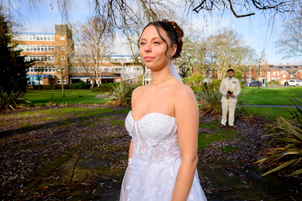Bride in a white wedding dress posing in the gardens near Sandwell Register Office.