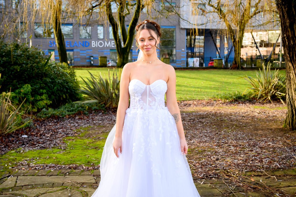Wide-angle shot of the bride standing alone in the park near Sandwell Register Office.