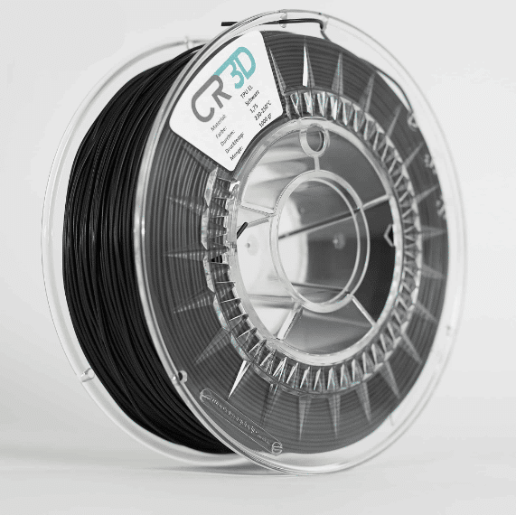 Seitliche Ansicht einer Spule mit schwarzem Filament, in einer transparenten Kunststoffverpackung.