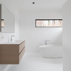 Salle de bain avec résine blanche au sol et baignoire en corian d'une réalisation contemporaine à Chaumont-Gistoux