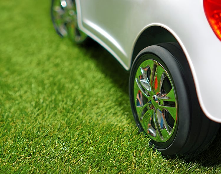 Children,electric,car,on,a,green,artificial,grass.,copy,space.