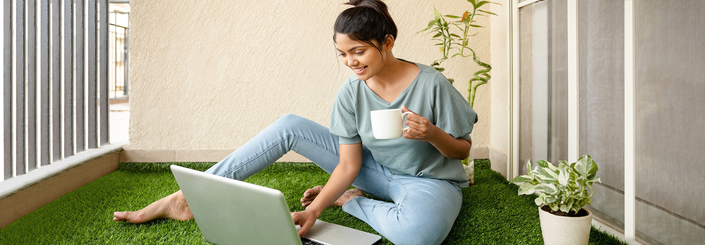 Hübsche,Junge,Frau,arbeitet,am,Laptop,auf,Balkon,Kunstrasen.