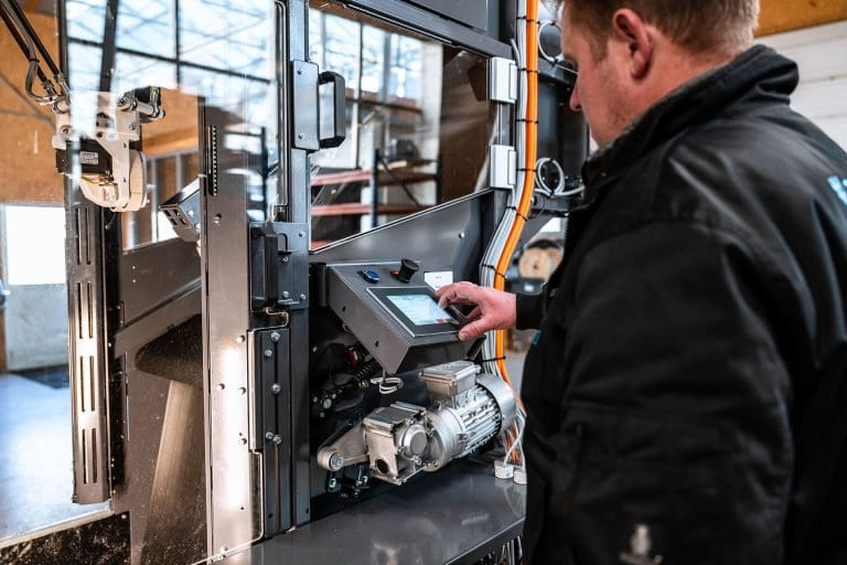 A man working with a small display on a Inwatec machine for soiled side sorting.