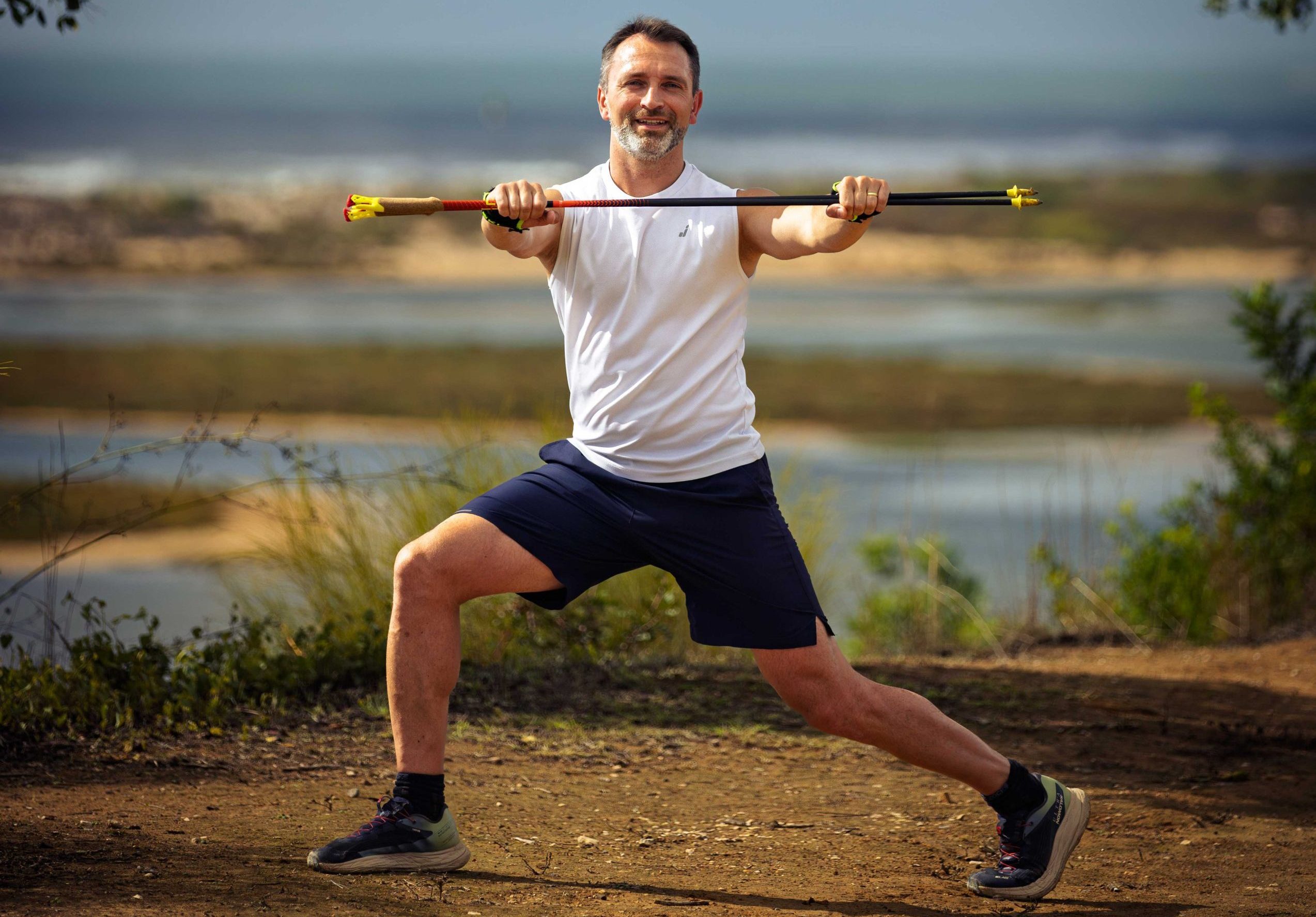 Fit & entspannt in Freiburg – Nordic Walking mit Lukas Jablonka Lukas Jablonka zeigt Übungen mit Nordic-Walking-Stöcken vor schöner Naturkulisse, ideal für sanfte Fitness und Beweglichkeit.