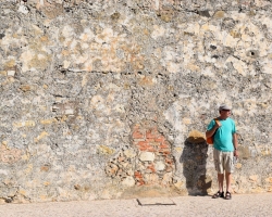 Äldre man (i gott skick!) framför gammal mur i Faro