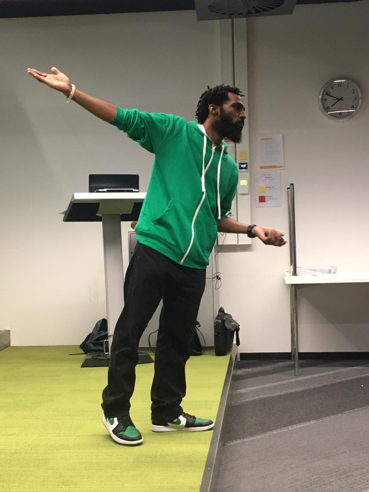 This is a photograph of the trainer and speaker Josuël Rogers pointing during a keynote speech