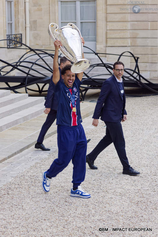 Le capitaine du PSG, Marquinhos, portant la coupe de la ligue des champions à l’Élysée