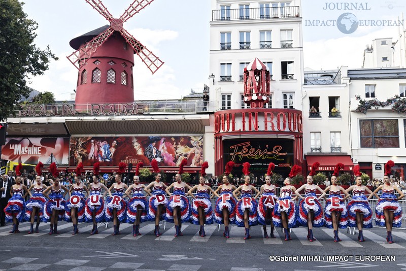 Les danseuses du Moulin Rouge présentent le tableau « TOUR DE FRANCE » devant le célèbre cabaret de la place Blanche à Paris.