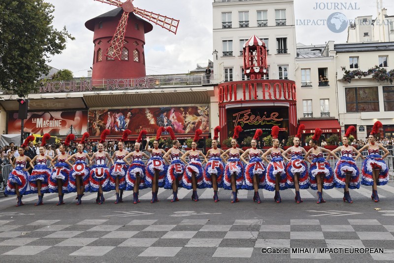 Les danseuses du Moulin Rouge présentent le tableau final « TOUR DE FRANCE » devant le célèbre cabaret de la place Blanche avant le passage des coureurs.