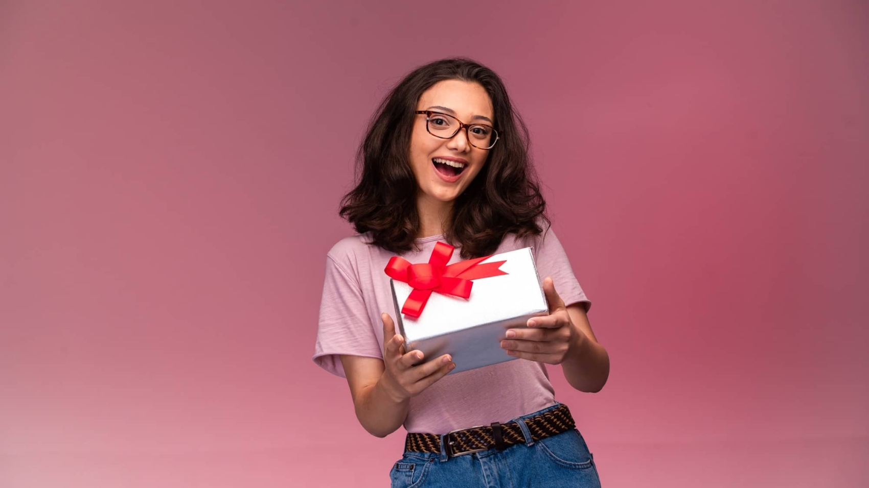 young-girl-eyeglasses-offering-white-gift-box-smiling
