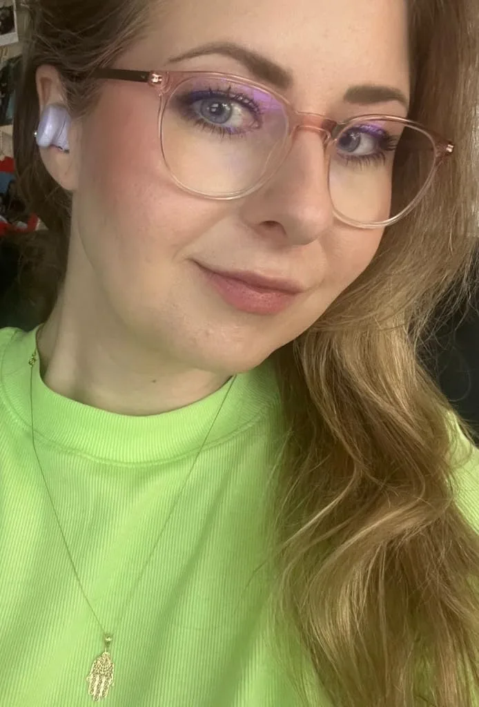 a woman wearing glasses and a green shirt