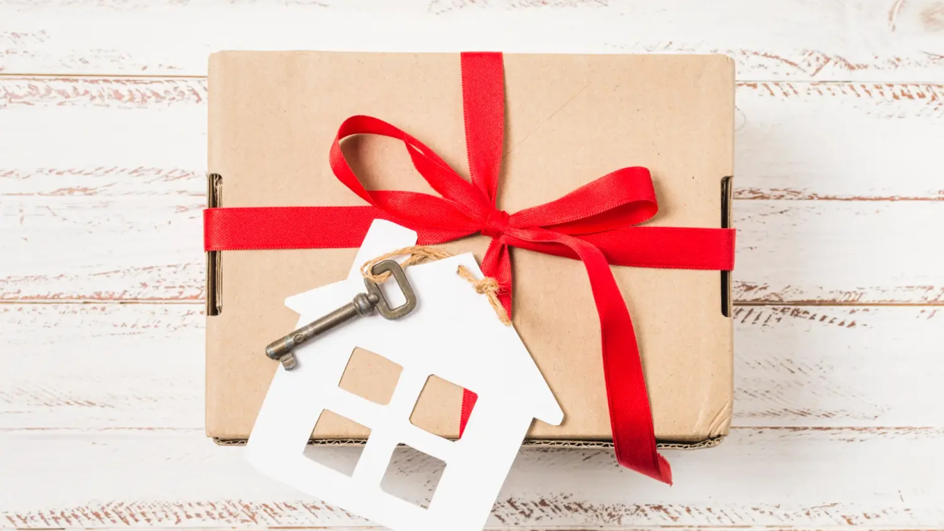 close-up-house-key-tied-with-red-ribbon-brown-gift-box-painted-wooden-desk (1)