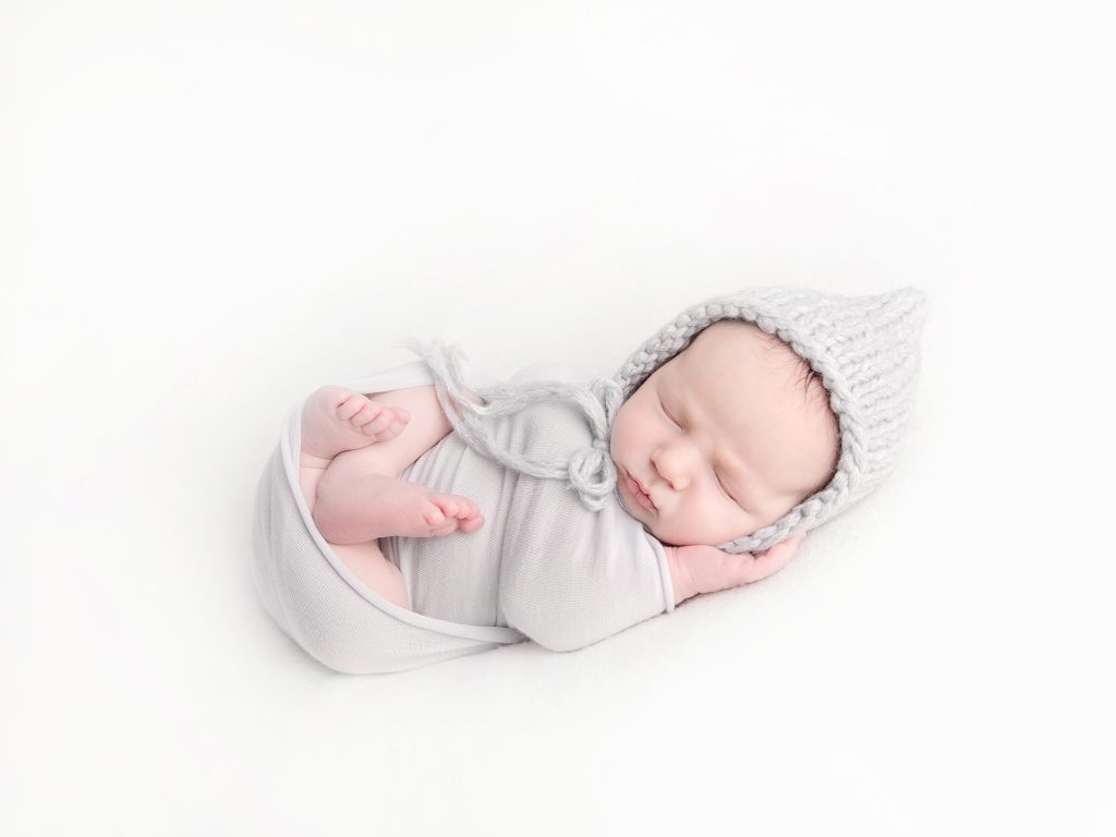 wrapped newborn with a hat posing newborn photographer edinburgh