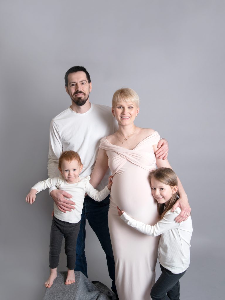 maternity posing with partner and two kids daughters studio photography