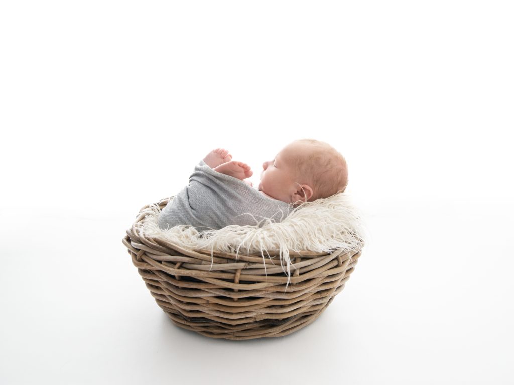 backlit newborn photography edinburgh posing in a basket